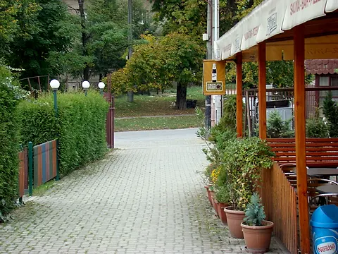 Dláždený vstup do areálu z ulice popri letnej terase reštaurácie