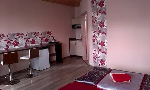 Pracovná doska s barovými stoličkami a malá kuchynka v izbe č. 11