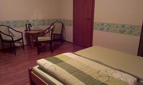 Stolík so stoličkami a posteľ v izbe č. 4