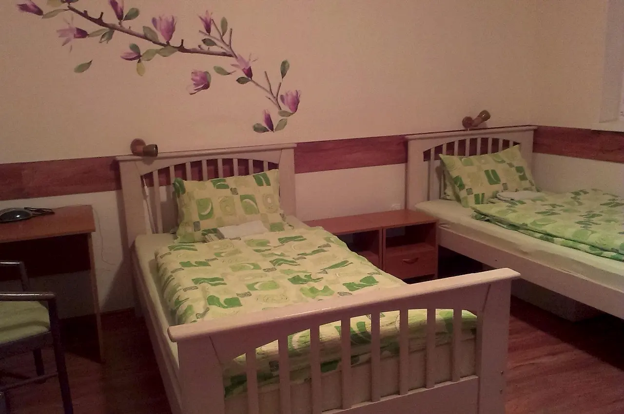 Tri samostatné postele so zelenou posteľnou bielizňou v izbe č. 6