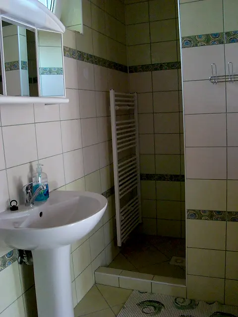 Kúpeľňa izby č. 4 so sprchovým kútom, umývadlom a sušiakom na uteráky