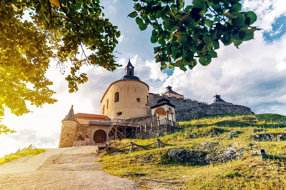 Hrad Krásna Hôrka na zelenom kopci v lete pod oblačnou oblohou