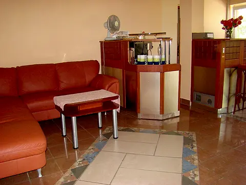 Recepcia s koženou sedačkou a drevenými pultmi